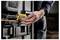 'TOUGHSYSTEM' case being securely latched by a person's hand, demonstrating durability and ease of use for tool storage.