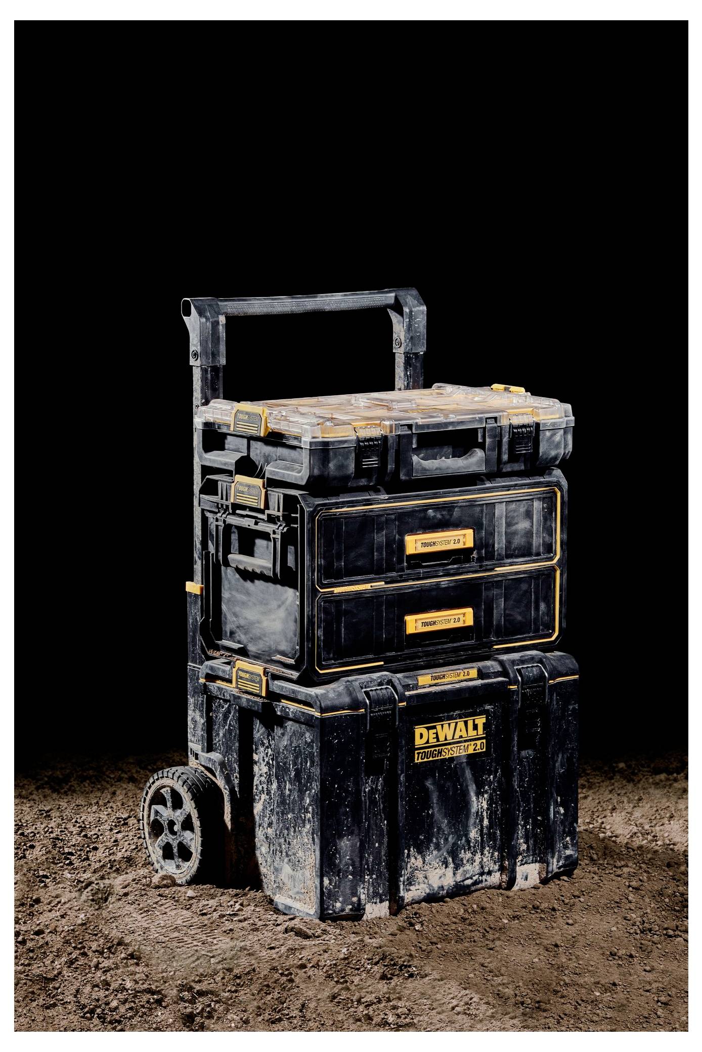 A rolling stack of black and yellow toolboxes on a dirt ground, labeled 'DEWALT,' showing ruggedness and organization for tools.
