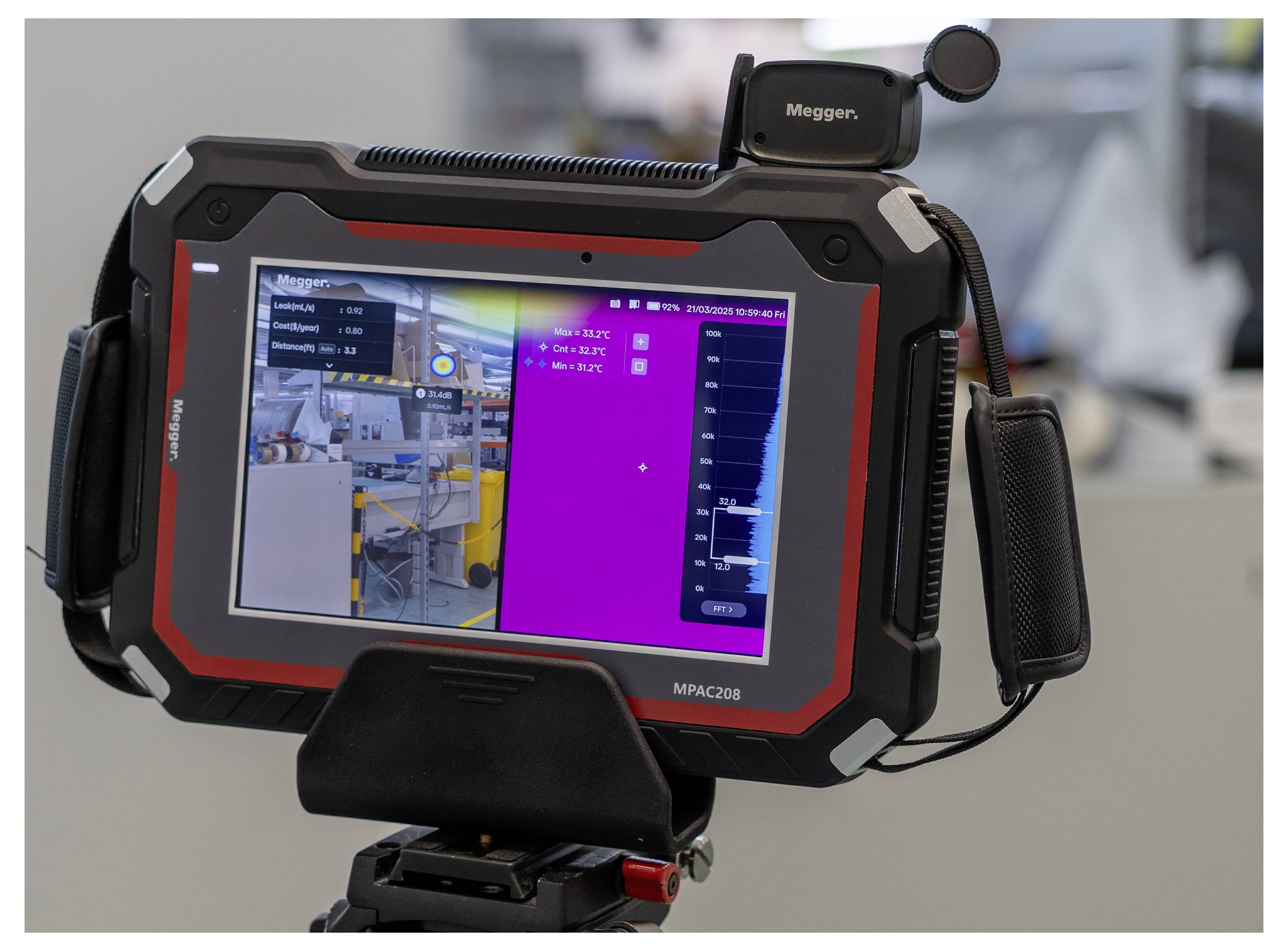 A tablet device showing a live image of an industrial workspace corner with measurement data displayed on the right side of the screen.