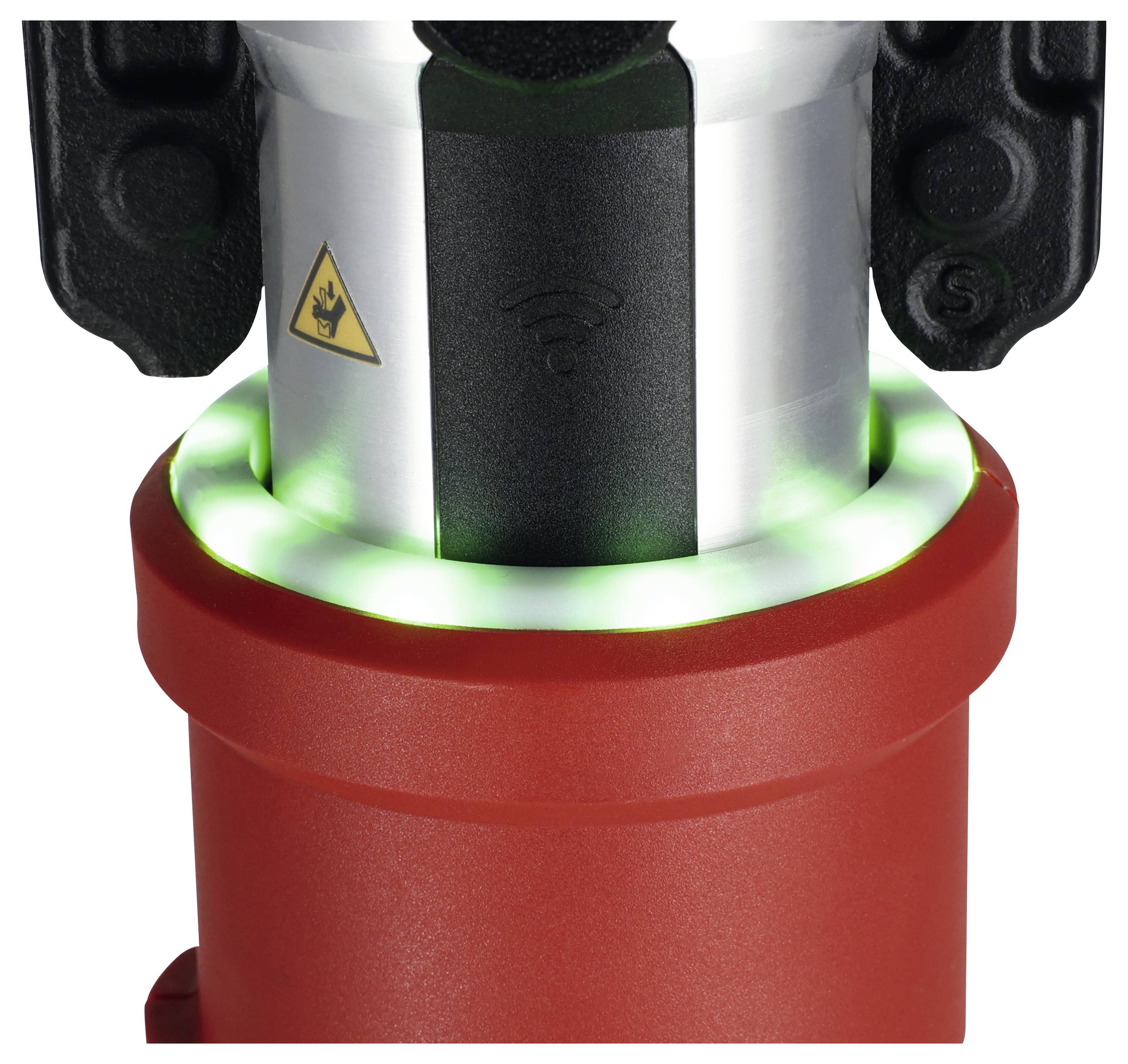 A tool with a red base and a metallic cylindrical top, featuring a wifi symbol and a triangular warning sign. A green LED ring is lit.