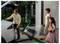 A family packing sports equipment and luggage into a car while a child holds a basketball and swim fins, preparing for a trip.