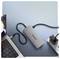 'A gray portable charger connected to a laptop and plugged into a power strip on a light blue background.'