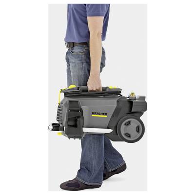 A person in jeans and a blue shirt carries a compact Kärcher pressure washer, showing its portability and ease of transport.