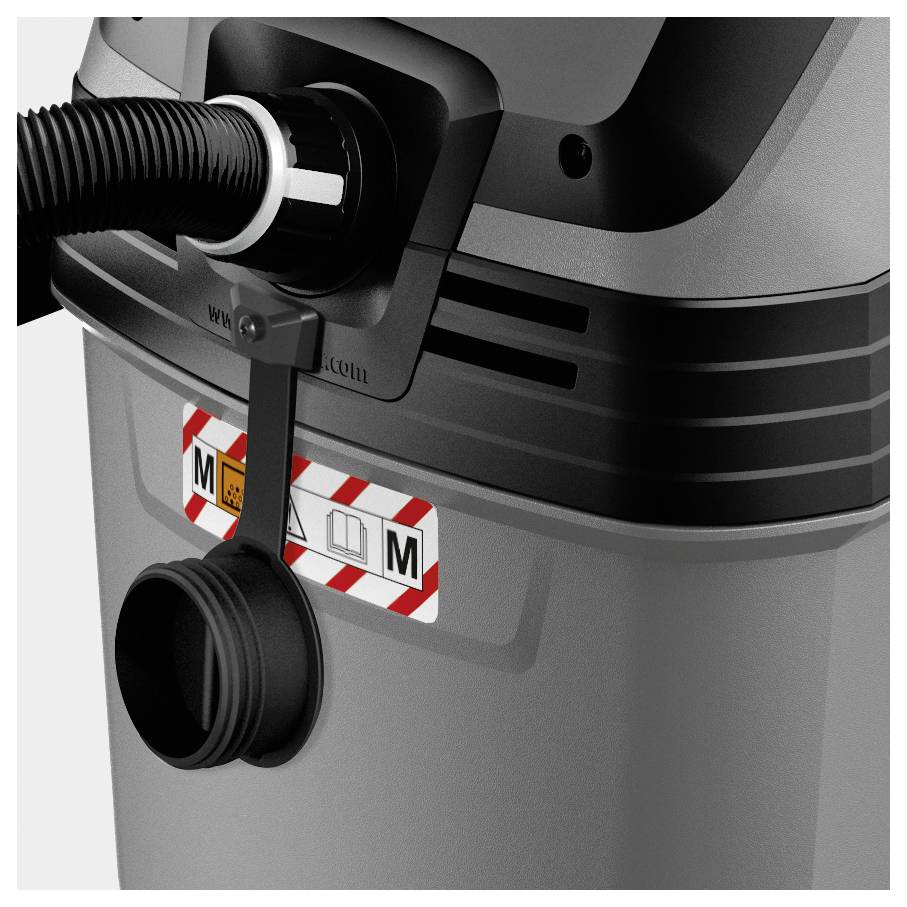 A close-up of a gray industrial vacuum cleaner's hose connection with safety and compliance labels indicating dust class M.