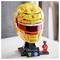 A yellow LEGO helmet resembling a racing helmet, with various sponsor logos. Beside it, a small LEGO figure in a red racing suit.