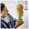 A person holding a detailed LEGO trophy resembling a gold cup. The set is for ages 12+ and contains 2,842 pieces.