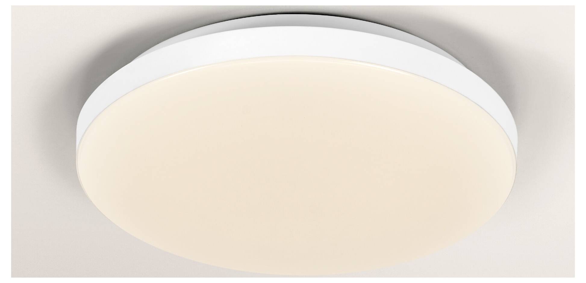 A circular, modern ceiling light with a smooth, white diffuser is mounted on a ceiling, emitting a soft, even glow.