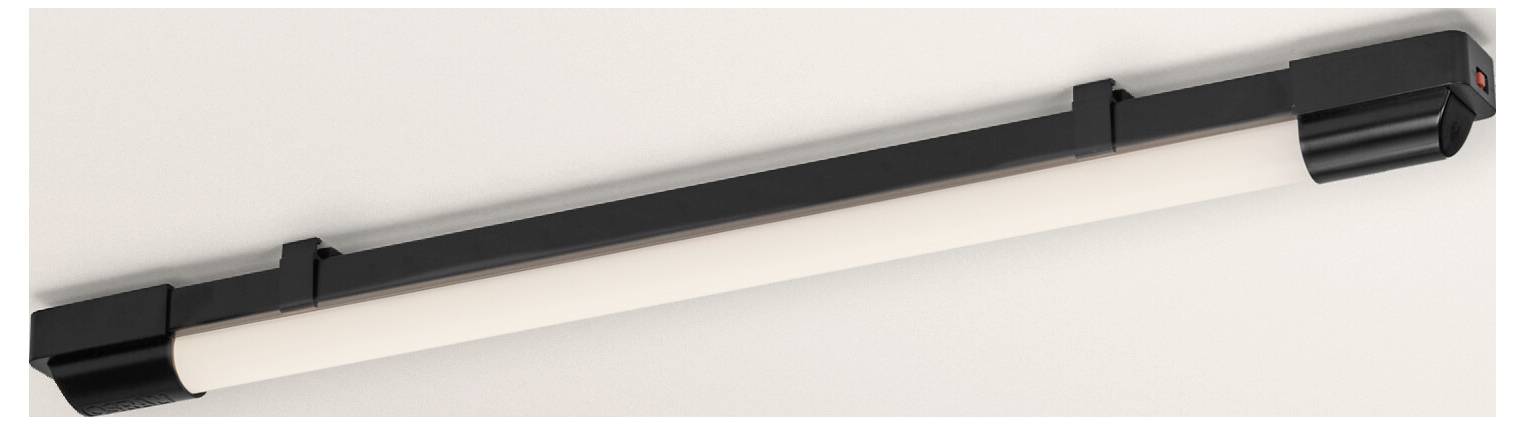 A sleek, black linear light fixture mounted on a white ceiling, designed for modern interiors, with a cylindrical, diffused tube.