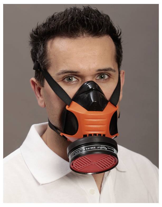 A person wearing an orange and black industrial respirator mask, posing against a neutral background.