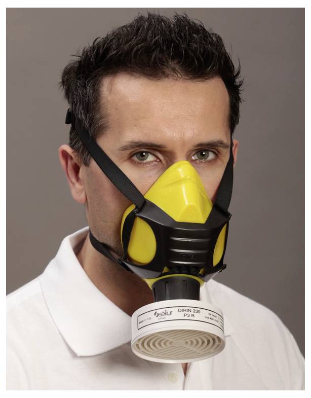 A person wearing a yellow and black protective mask with a round filter, wearing a white shirt, against a neutral background.