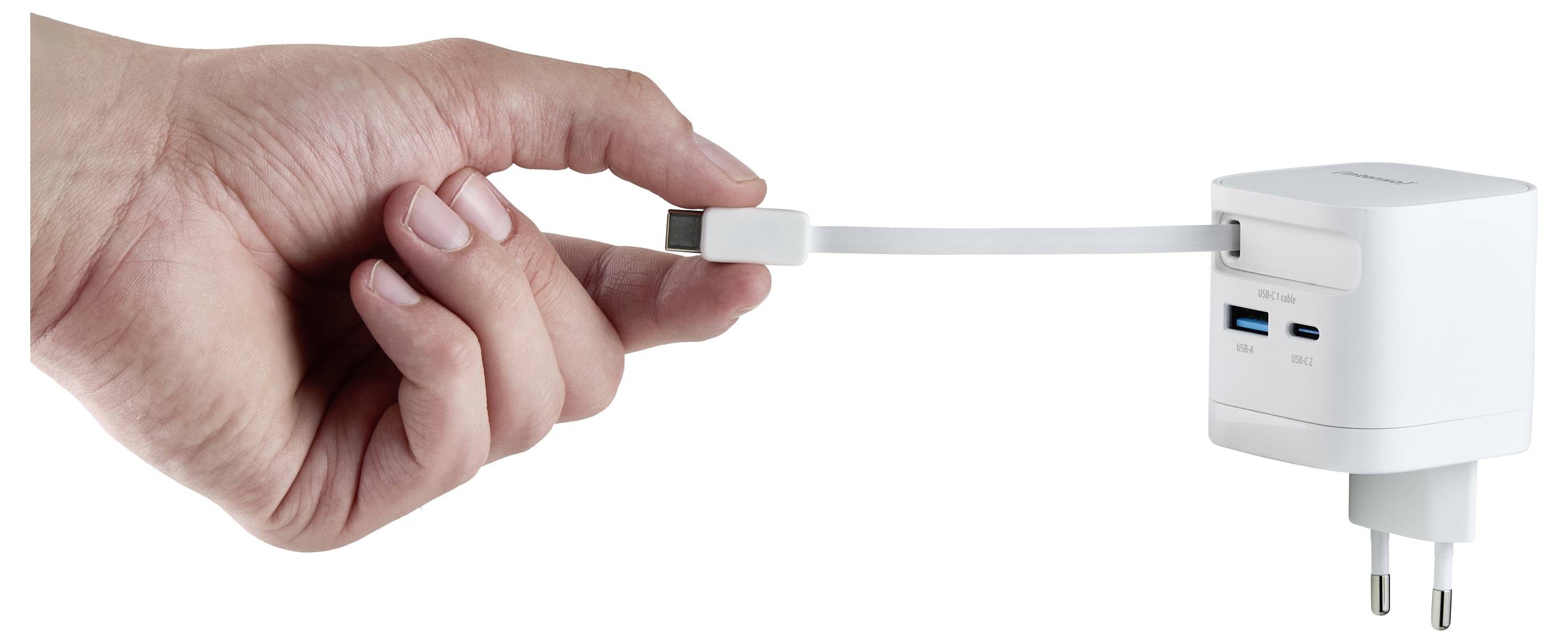 A hand holding a USB plug about to connect it to a white wall charger with multiple ports.