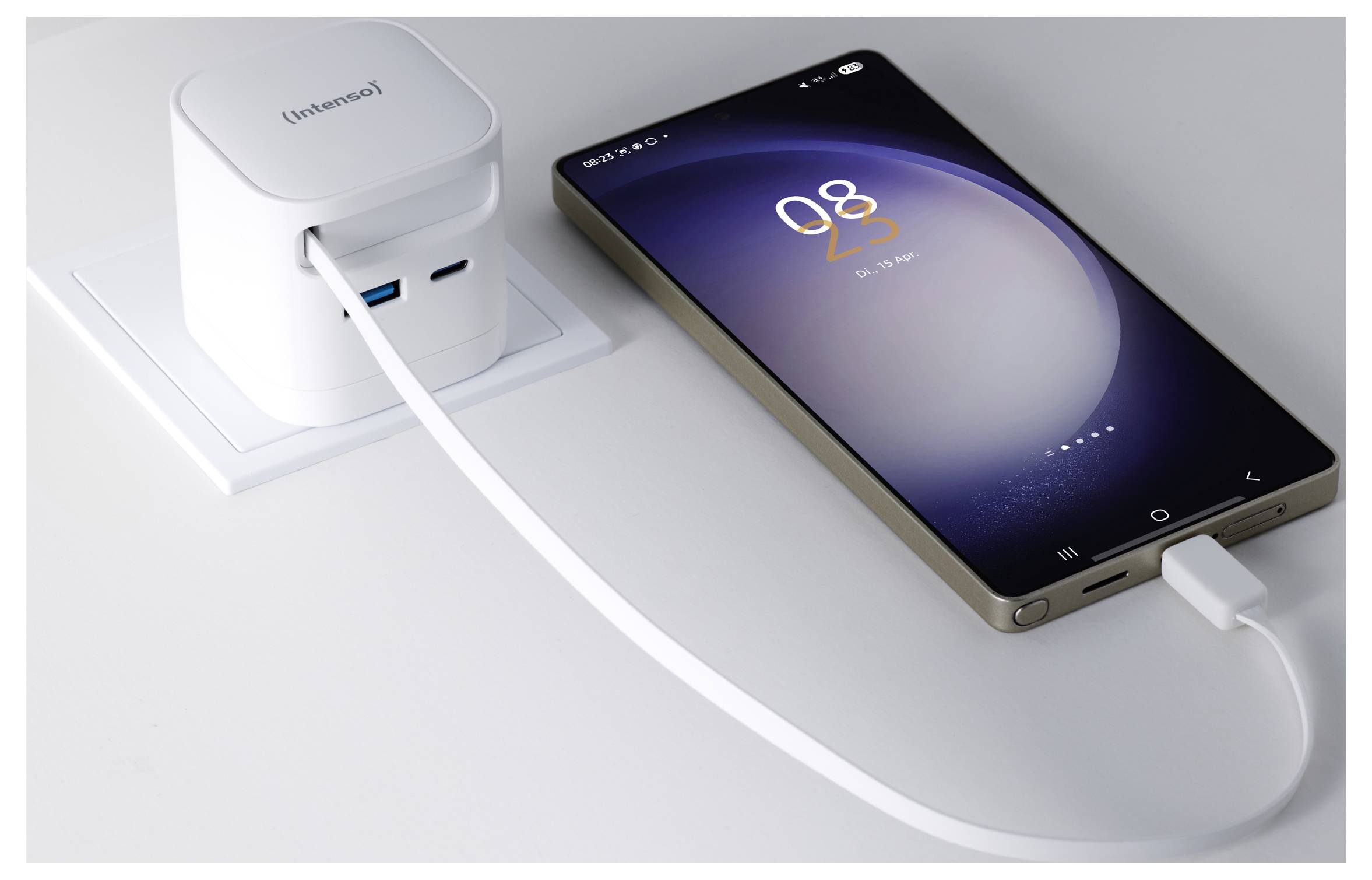 A smartphone charging on a table, connected to a white wall charger. The phone screen displays the time as 08:25.