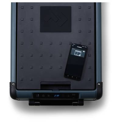 A smartphone rests on a large dark rectangular device with a digital display, suggesting a smart-controlled appliance or carrier unit.