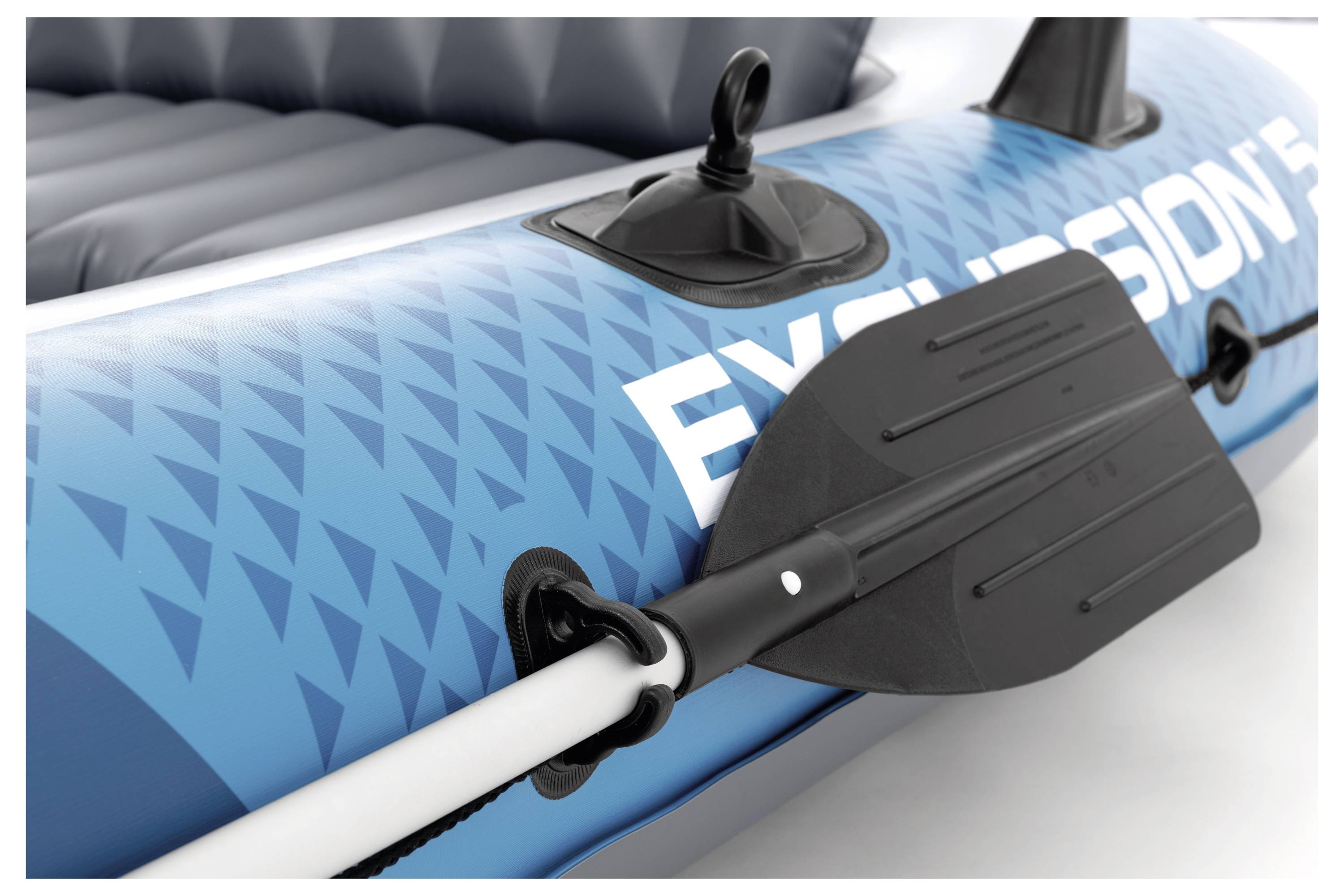 A black oar secured in a clasp on a blue inflatable boat with the partially visible word 'EXCURSION.'