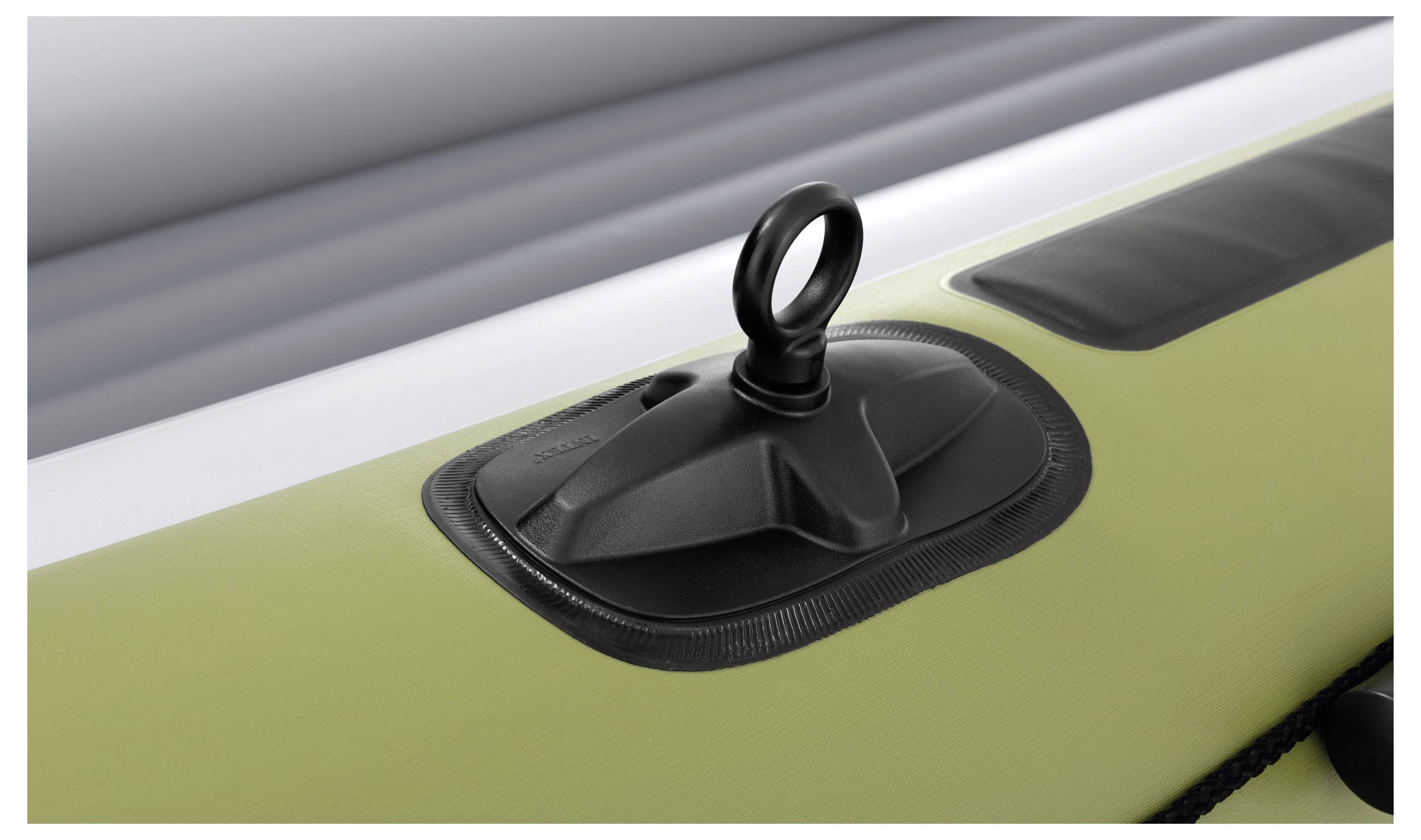 Close-up of a green inflatable boat's air valve and handle, showing the texture and design for secure inflation and transport.