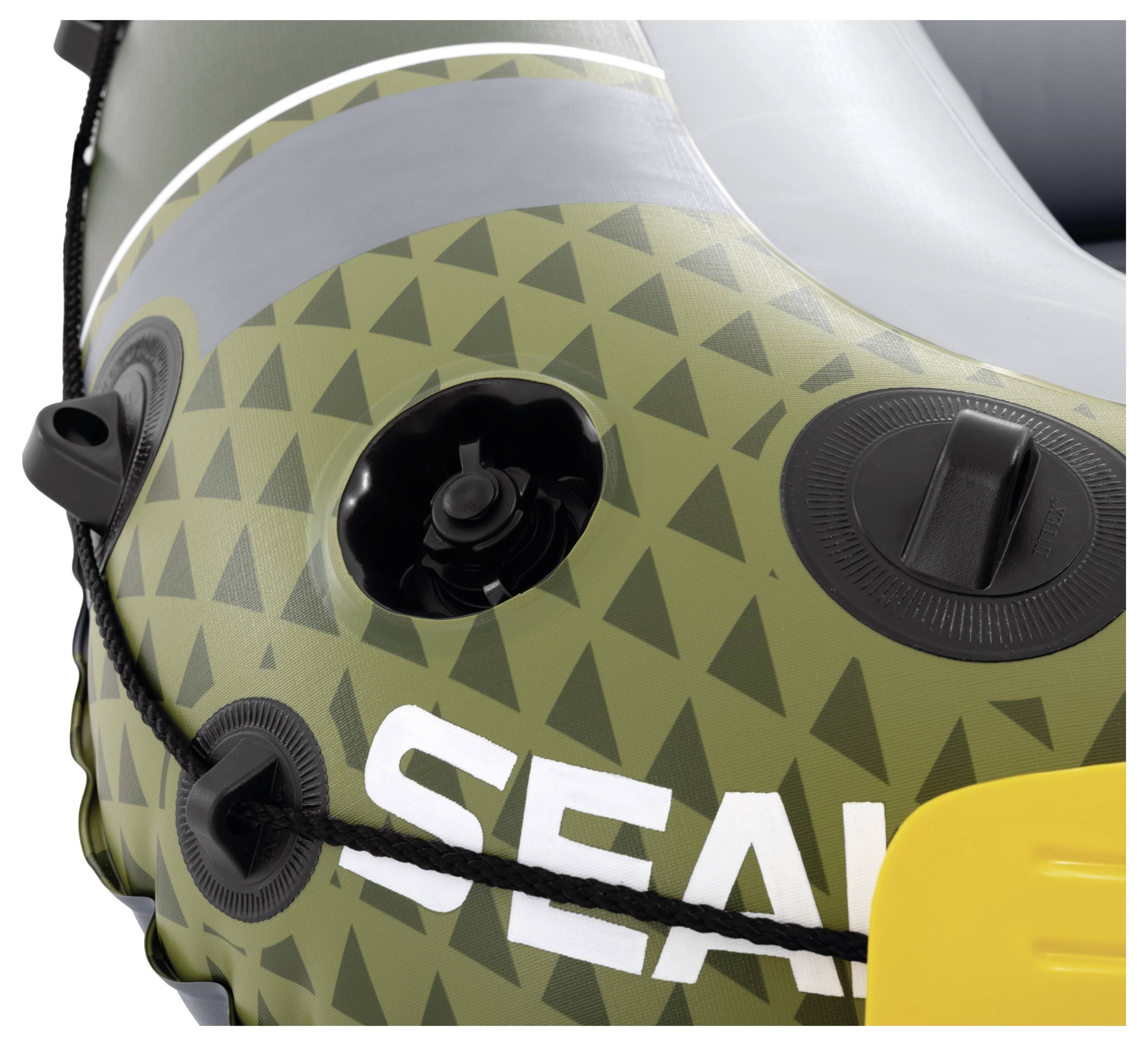 Close-up of an inflatable boat with green triangular pattern and 'SEAL' text in white. Features valves for inflation and a black rope.