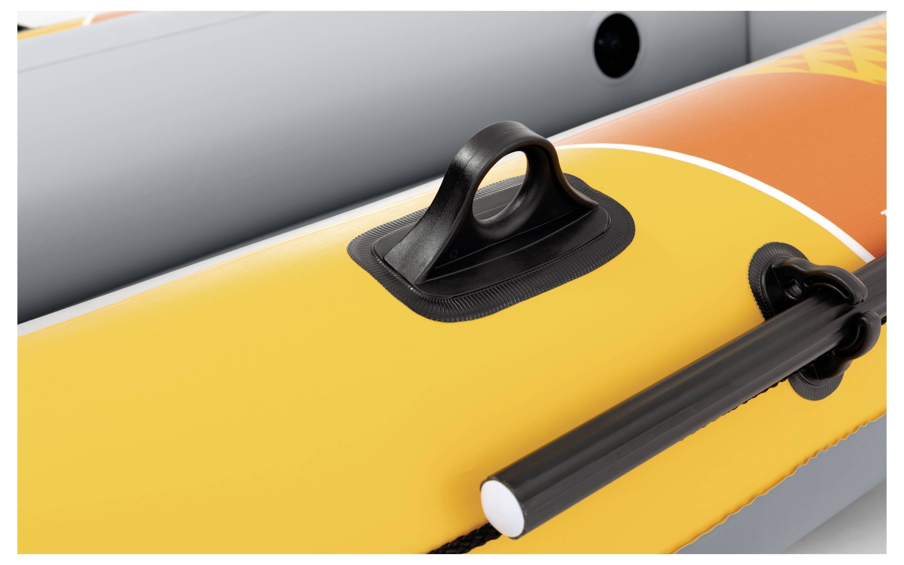 'Close-up of a yellow inflatable boat with a black handle and oar attachment.'
