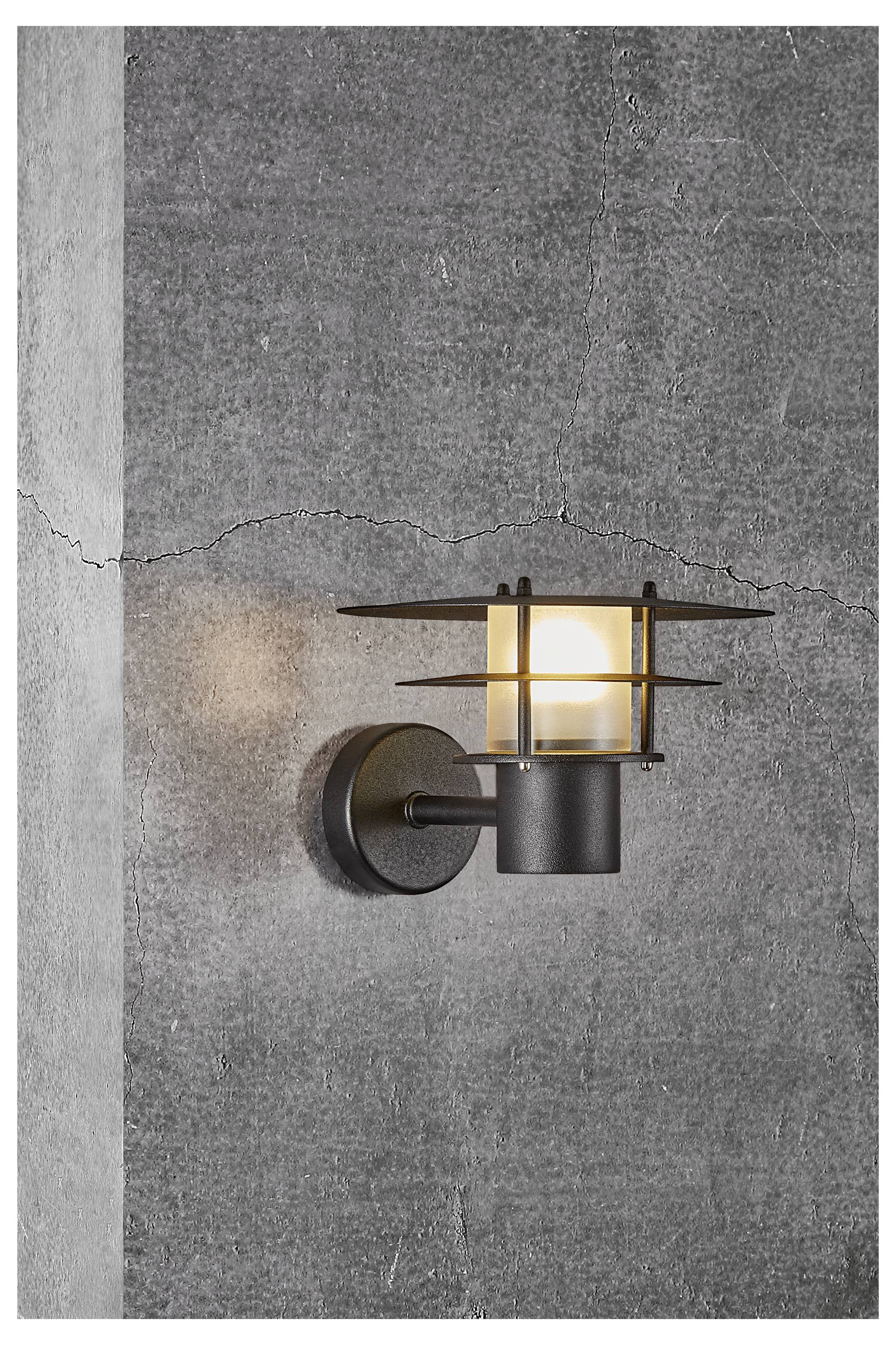 A wall-mounted, modern black lantern with a glowing light bulb, attached to a textured gray stone wall with a visible crack.