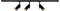 'Black track lighting fixture with three adjustable spotlights, each emitting warm light aimed downward.'
