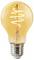 A warm glowing LED light bulb with a visible spiral filament, set against a plain background.