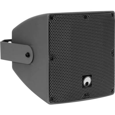 A wall-mounted black speaker with a protective mesh cover, suitable for outdoor use, featuring a logo in the center of the front panel.