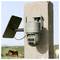 A security camera mounted on a wooden post overlooks a rural landscape with a grazing horse in the background.