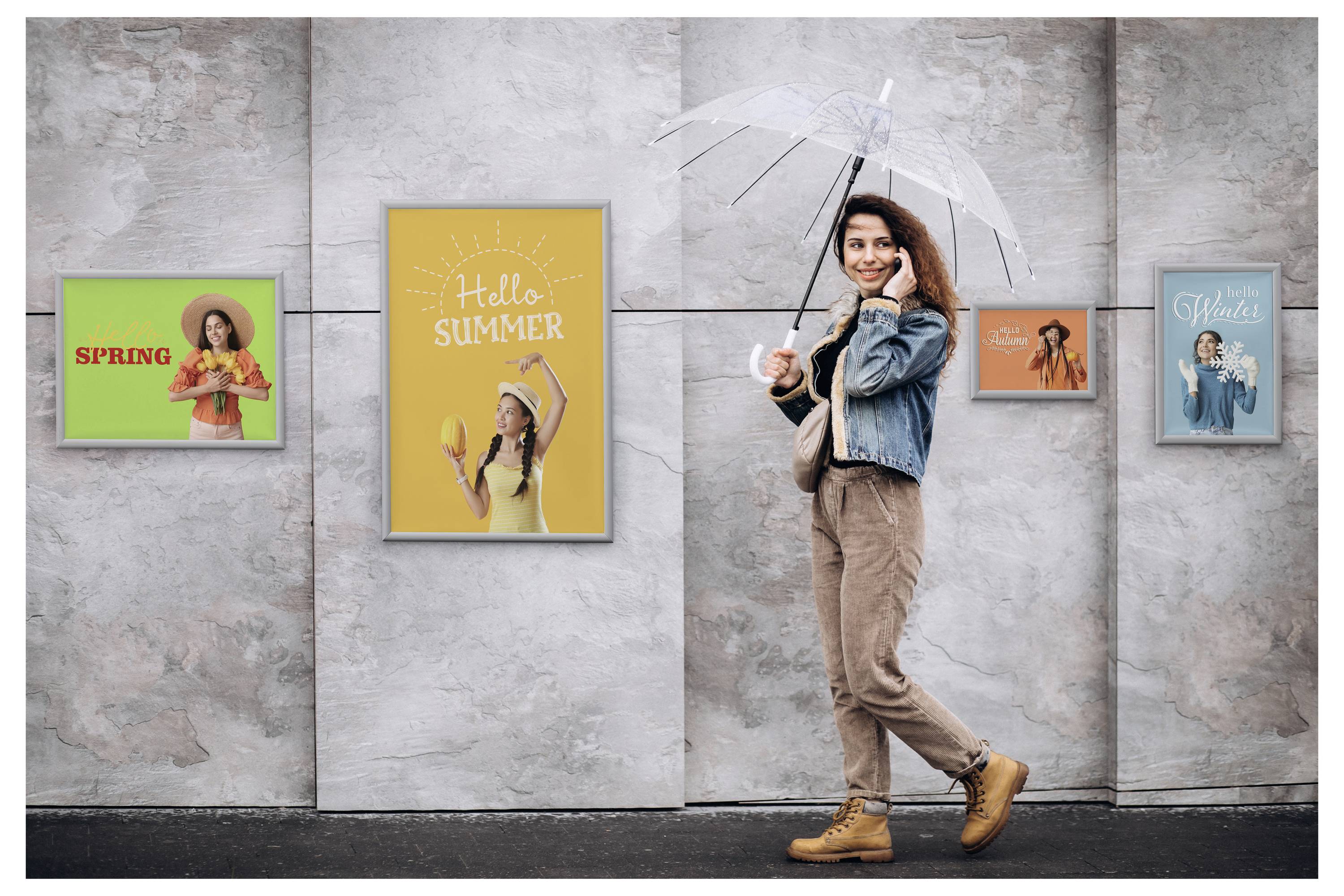 A woman holding a transparent umbrella walks past a wall displaying four seasonal-themed posters labeled 'Hello Spring', 'Hello Summer', and others.