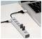 USB hub connected to a laptop, with multiple ports and one empty outlet visible on a desk.