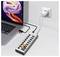 Laptop connected to a multiport charging hub plugged into a wall outlet, with several USB devices and AC plugs attached.<br>