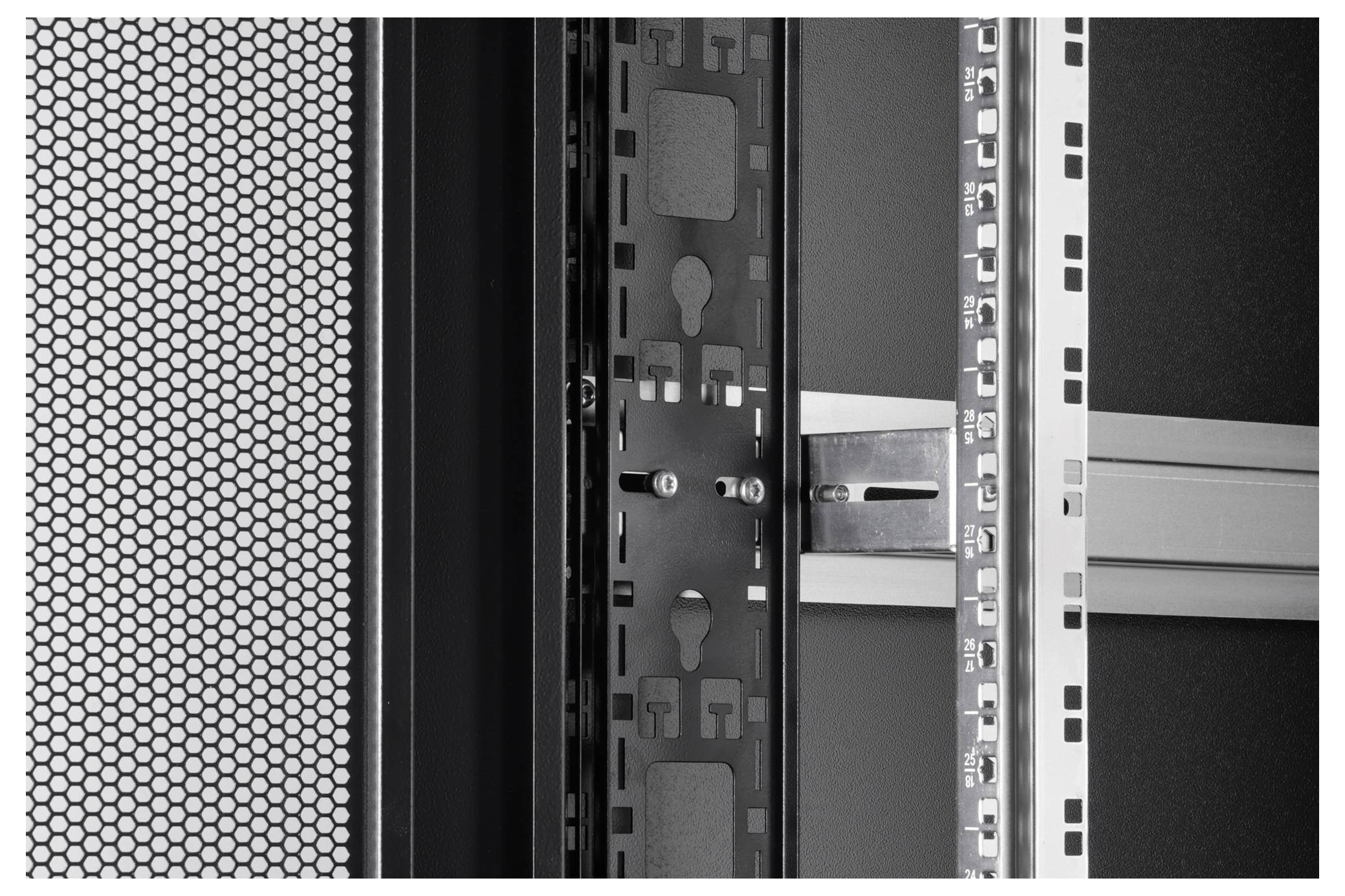 Close-up of a server rack with perforated door on the left, showing empty shelves and metal framework inside a data center.