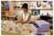 A person sits at a desk, using a smartphone and operating a purple printer to print custom designs on round and rectangular items.
