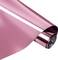 A roll of shiny pink metallic foil reflects light, with the foil partially unrolled.