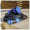 A coiled black extension cable with blue connectors placed on a wooden surface, suggesting outdoor or construction site use.