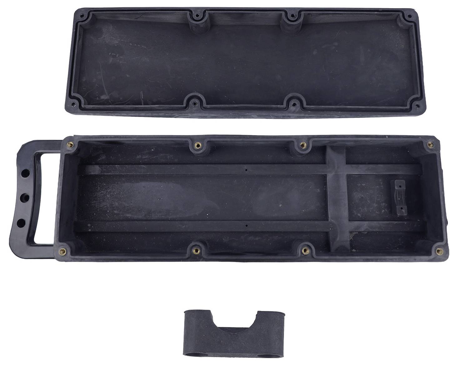 'Plastic casing of a portable device, open to show internal compartments and handle. Includes a central divider piece beneath the main case.'
