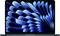 A laptop screen displays an abstract pattern of blue and black shapes radiating from the center, resembling waves or petals.