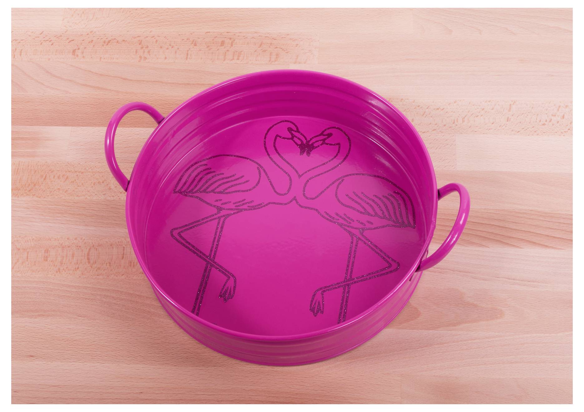 A pink metal tray with two flamingos facing each other inside, forming a heart shape with their necks and heads. The tray has side handles.