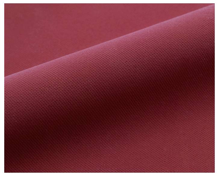 A close-up of red textured fabric, showing the weave pattern and a fold creating depth.