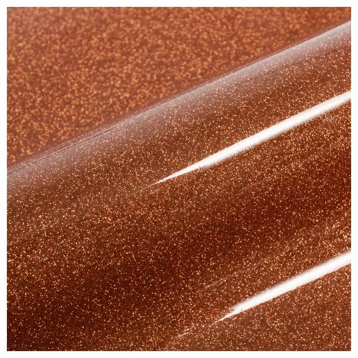 A close-up of a metallic orange surface with a glittery finish, reflecting light.