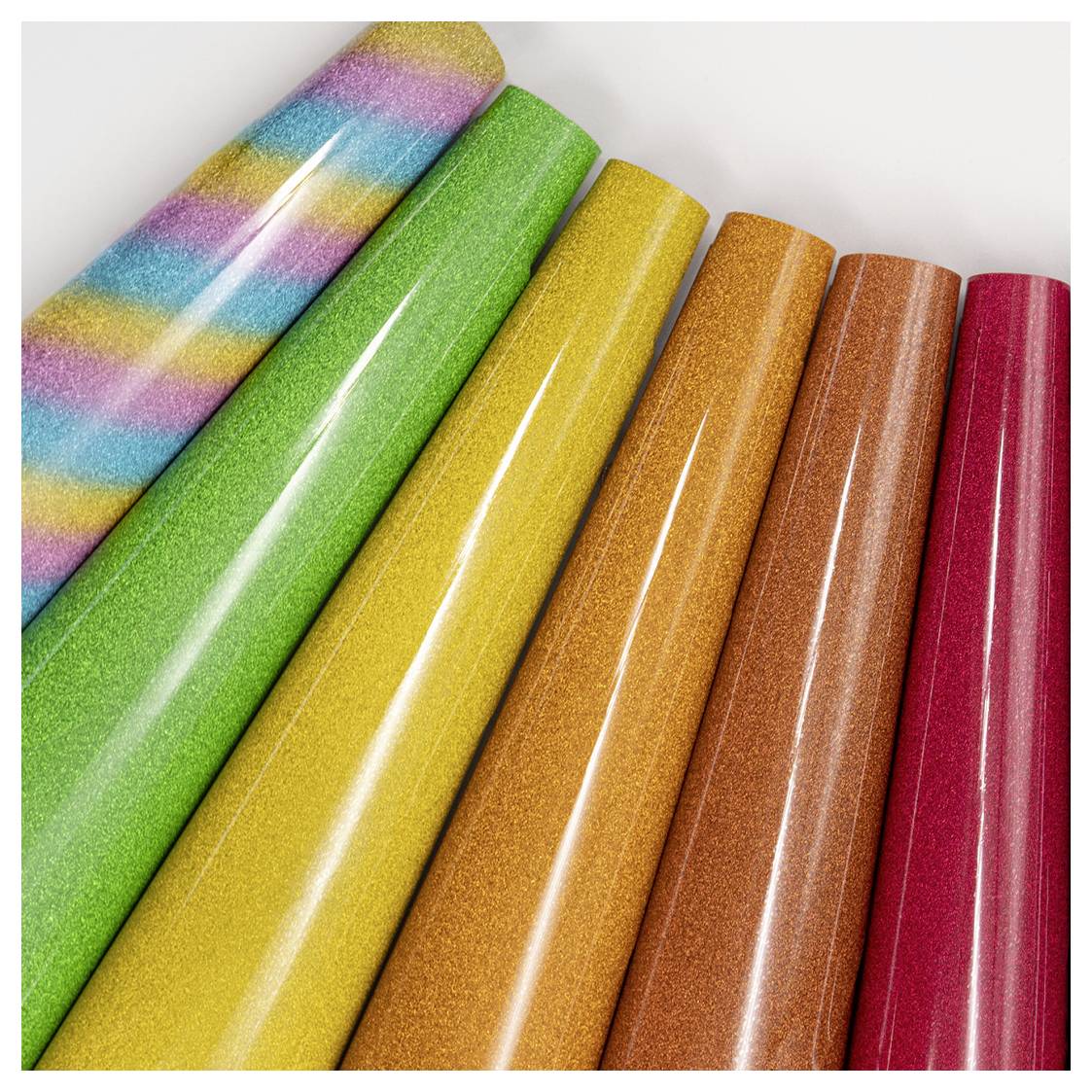 Colorful, sparkling rolls of wrapping paper arranged in a diagonal line, featuring a striped and various solid colors: green, yellow, orange, pink.