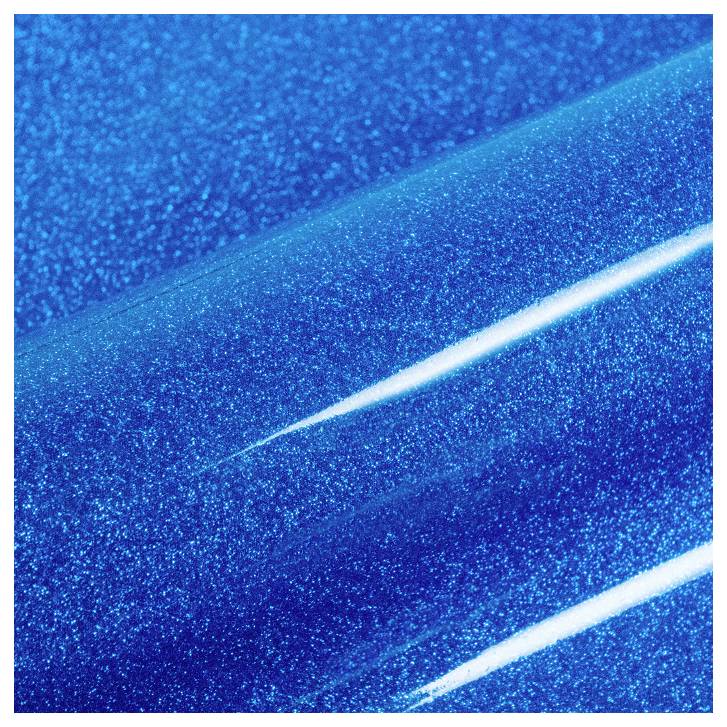 A close-up of a blue glittery surface with a shiny, reflective finish, showing diagonal streaks of light.