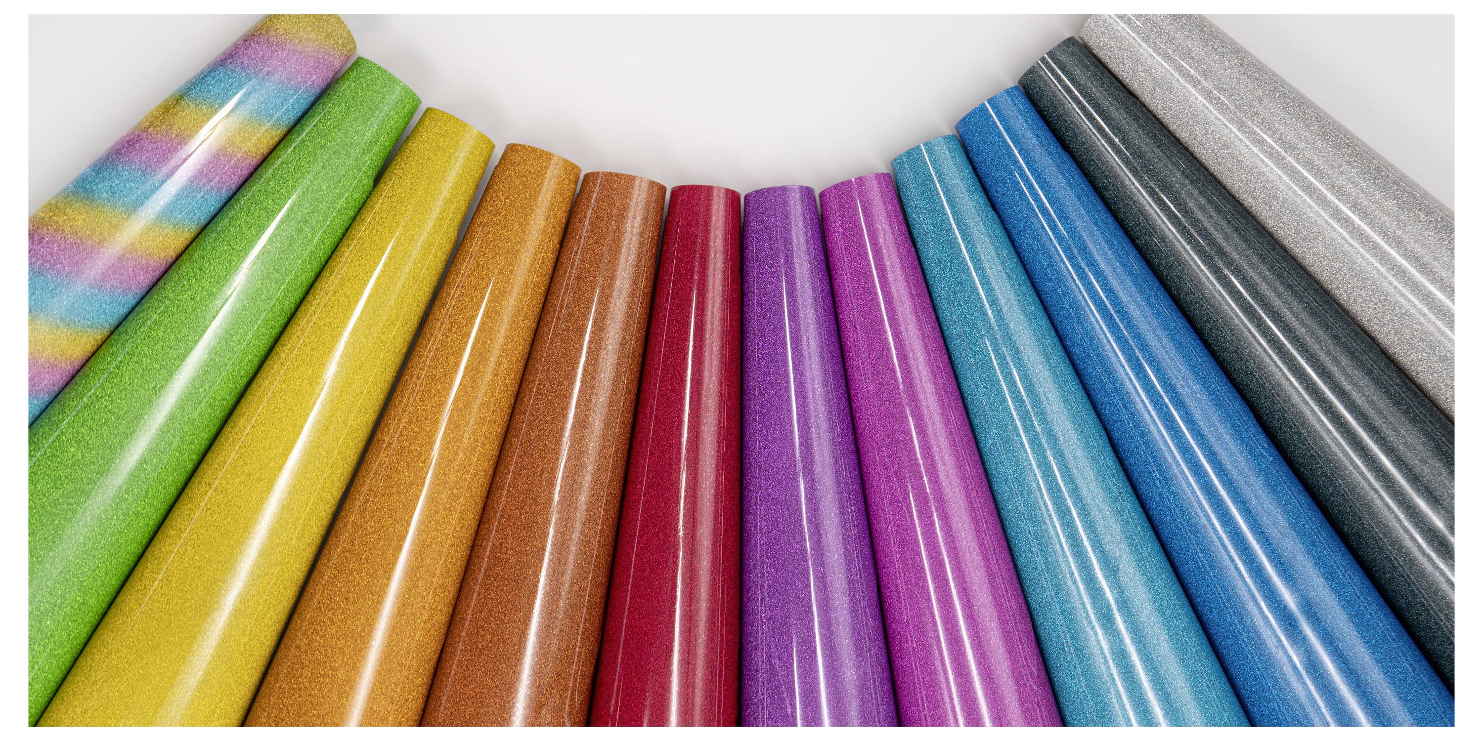 A row of colorful wrapping paper rolls arranged in a fan shape, featuring various bright colors including stripes, glitters, and solids.