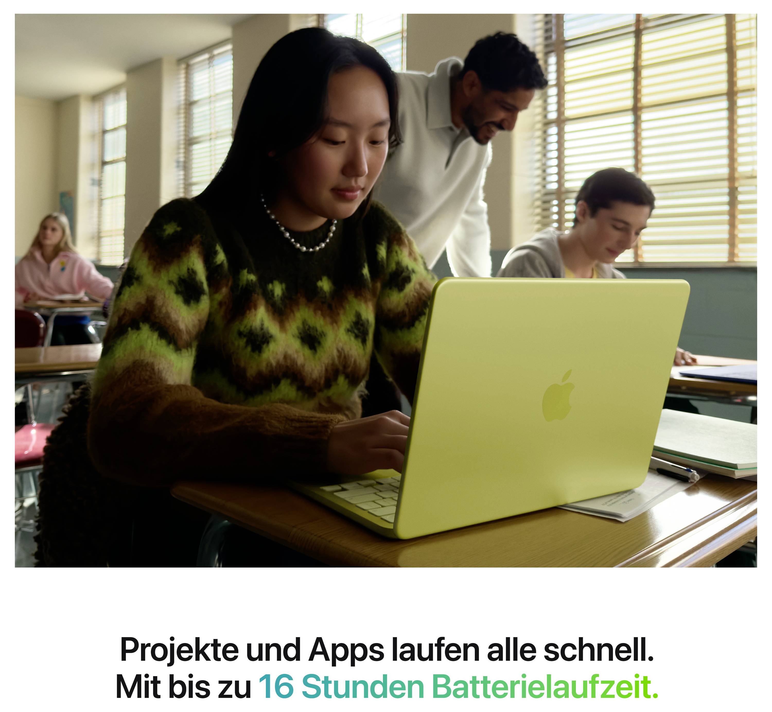 A person is working on a light green laptop in a classroom, whilst two other people interact. Text below mentions fast processing speed and "16 hours battery life".