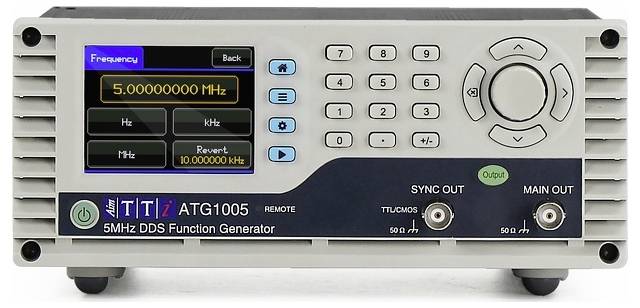 A TTI ATG1005 5MHz DDS function generator displaying a frequency of 5.000000 MHz. It features a numeric keypad and output jacks.