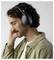 A person with curly hair and a mustache is wearing black over-ear headphones, with their eyes closed, suggesting they are enjoying music.
