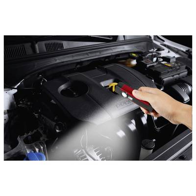 Hand using a digital flashlight to inspect a car engine bay under the hood.
