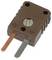 A brown thermocouple connector with a screw in the center, featuring two prongs; one is copper, and the other is silver.