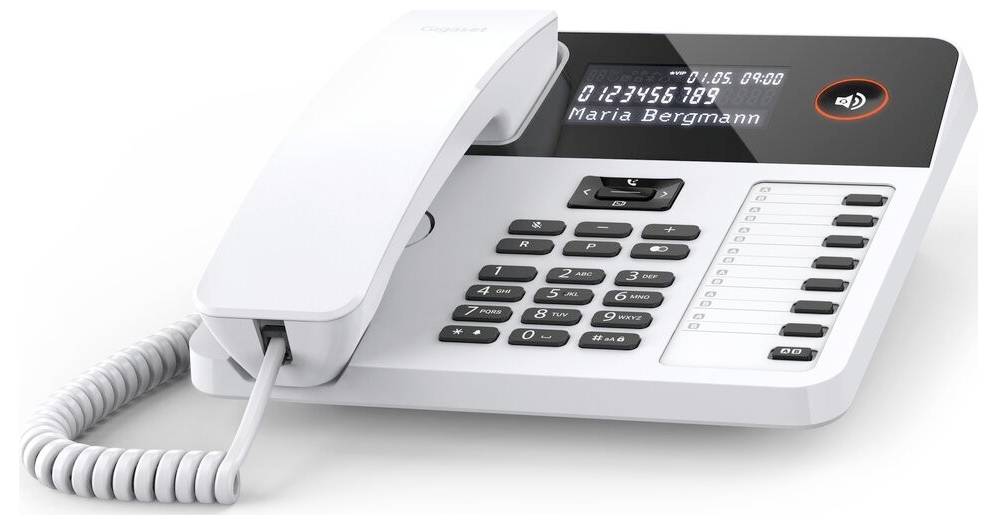A white office desk phone with a digital display showing the time and caller ID 'Maria Bergmann'. The keypad includes speed dial buttons.
