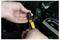 'A person using a voltage tester in a car engine compartment to check electrical connections.'