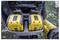 'Two yellow DEWALT batteries in a black charger, positioned outdoors on a grass surface with scattered leaves.'