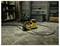 'A yellow portable air compressor with a hose lies on a concrete floor in a garage, surrounded by shelves and storage containers.'